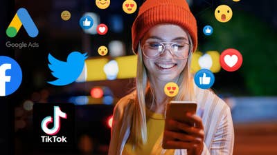 A smiling woman on her cell phone surrounded by emojis and social platform logos